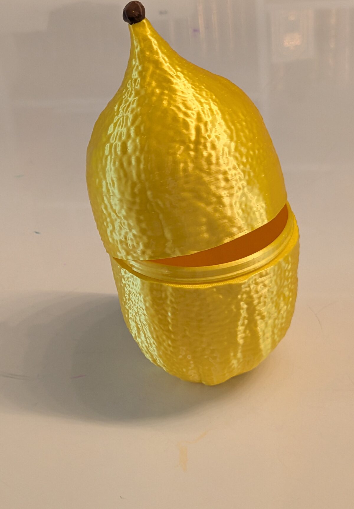 The etrog case mid-twist, cap lifting away from the base to reveal the hollow interior.